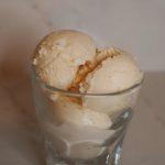 three scoops of blood orange ice cream in a clear glass.