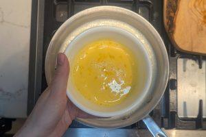 whisked egg yolks and cream in a bowl.