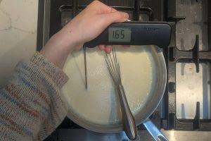 custard ice cream base in a saucepan with a thermometer reading "165°F".