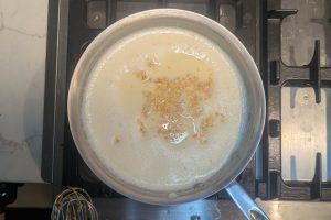 blood orange zest added to custard ice cream base in a saucepan.