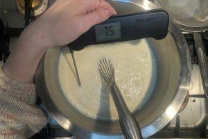 blood orange custard in an ice bath with a thermometer reading "75°F".