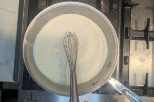 sugar, guar gum, and skim milk powder in a saucepan with a whisk.