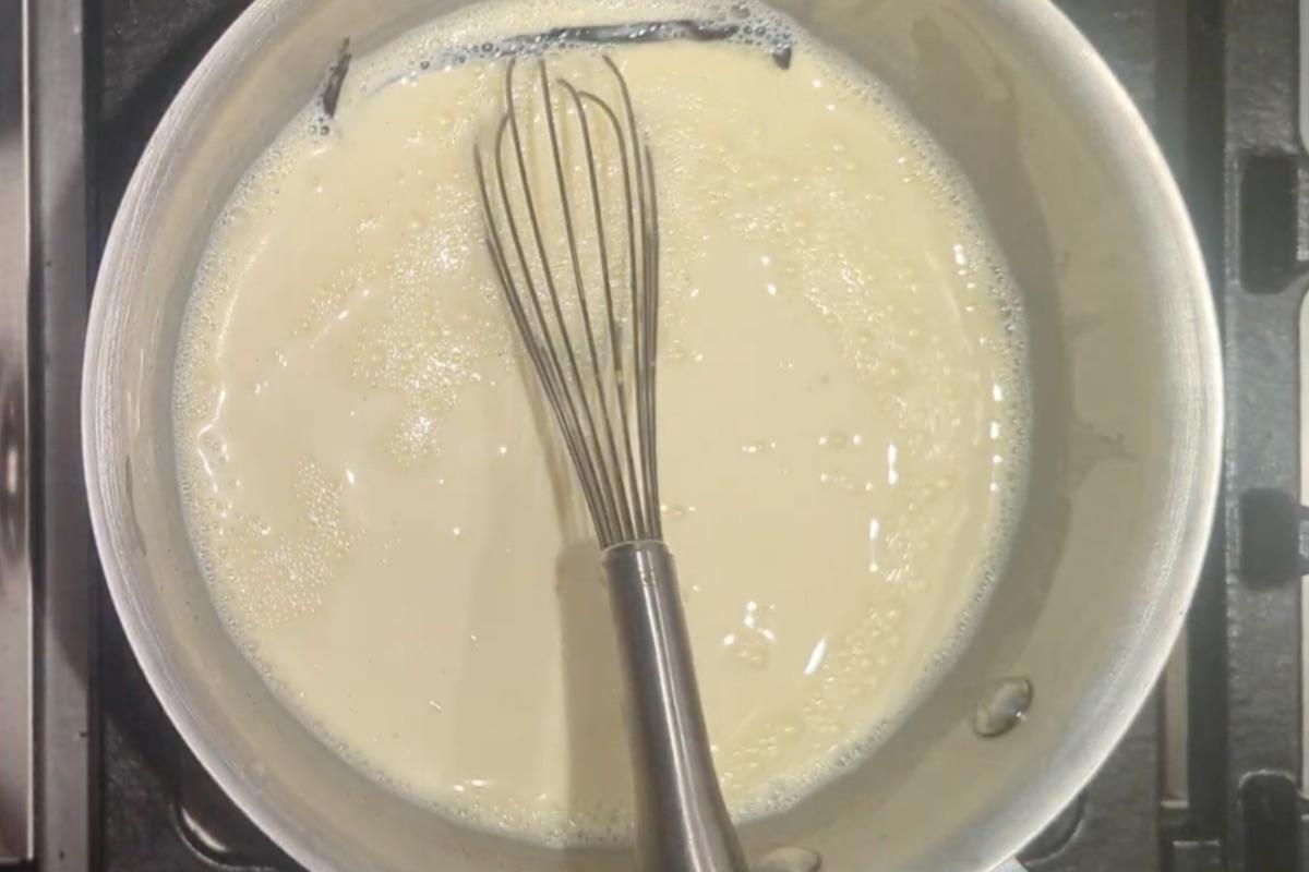 custard ice cream base in a saucepan with a whisk.
