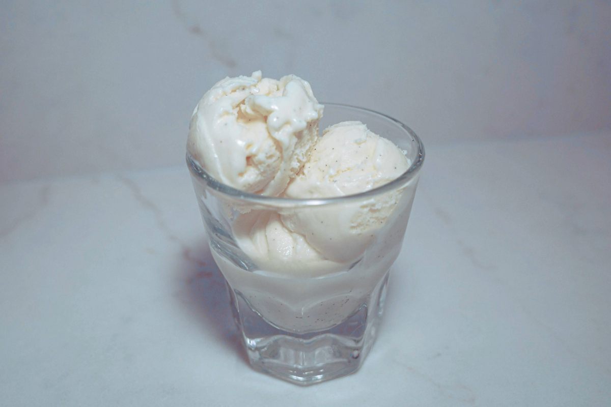 3 scoops of vanilla bean ice cream in a glass.