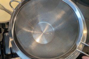 a fine-mesh sieve set in a stainless bowl.