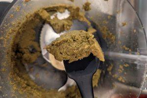 overhead view of ground pistachio paste on a rubber spatula.