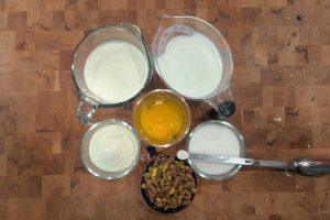 overhead view of portioned ingredients for pistachio ice cream on a wooden butcher block.