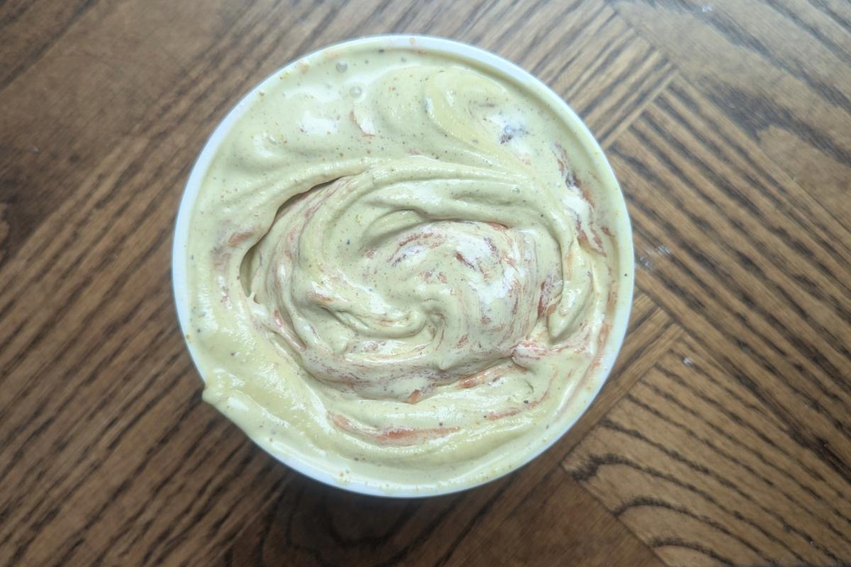 overhead view of a freshly packed pint of pistachio ice cream with rhubarb jam swirl.