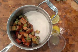 ingredients for rhubarb jam on a wooden butcher block.
