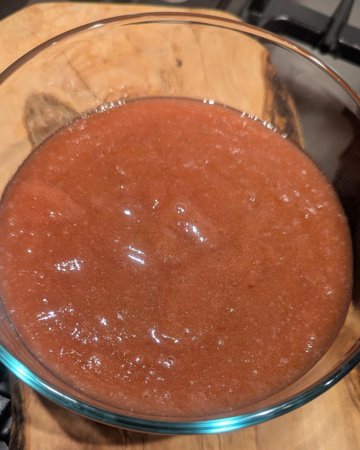 thick pink homemade rhubarb jam in a glass container.