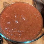 thick pink homemade rhubarb jam in a glass container.