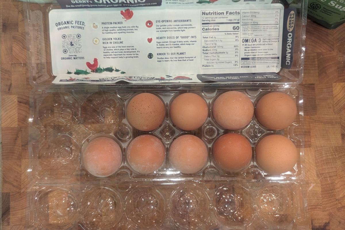 overhead view of nine eggs in a plastic carton.
