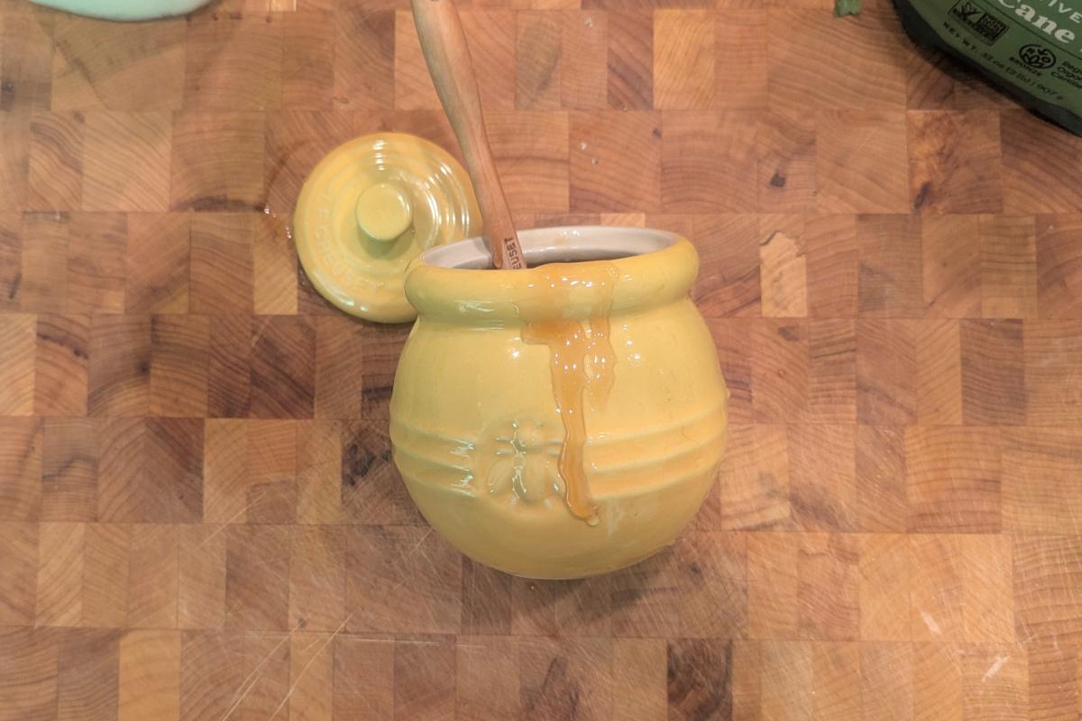 overhead view of a honeypot with honey dripping down the side.