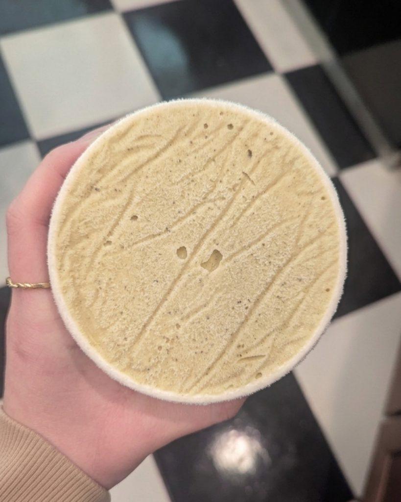 overhead view of a pint of pistachio icy ice cream with a fine layer of ice on top.