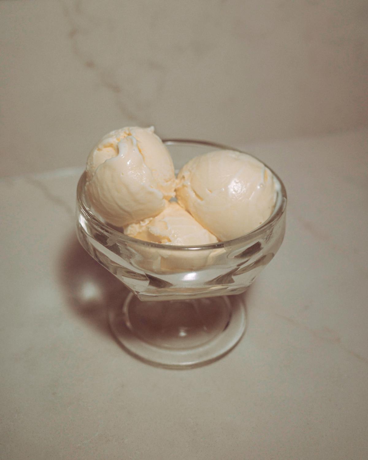 three scoops of sweet cream custard ice cream in a glass.
