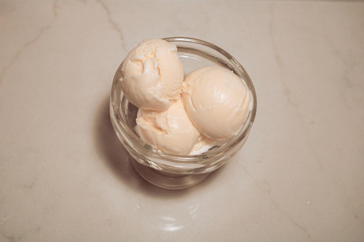 overhead view of three scoops of sweet cream custard ice cream in a glass.