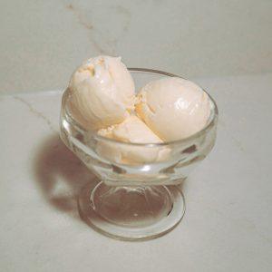 three scoops of sweet cream custard ice cream in a glass.