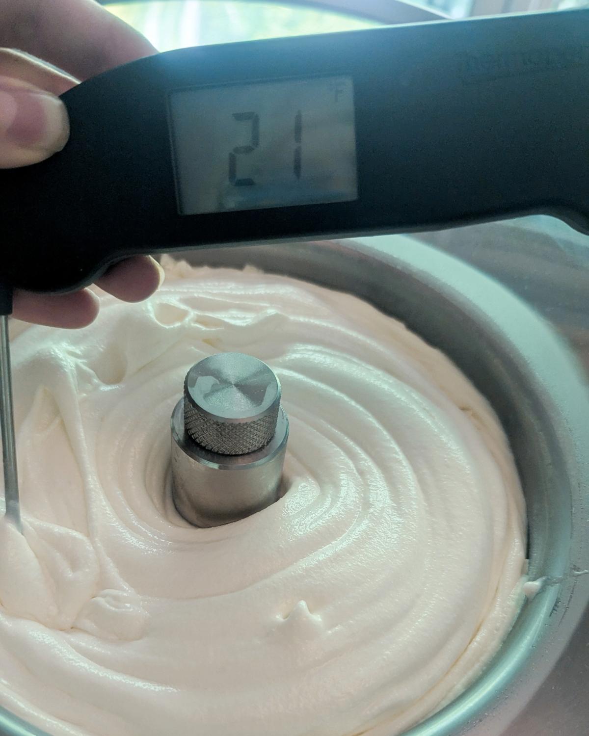 closeup of an instant-read thermometer showing the correct 21°F draw temperature for ice cream. Trust the thermometer over the clock for how long to churn ice cream.