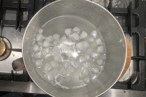 overhead view of an ice bath in a stainless bowl.