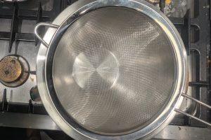 a fine mesh sieve set over a bowl on an ice bath.