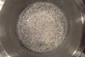 poppy seeds mixed into lemon ice cream base in a bowl.