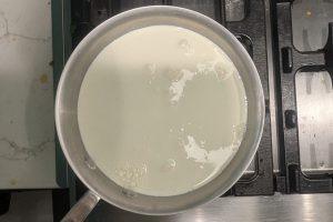 whole milk and heavy cream poured over sugar and skim milk powder in a saucepan.
