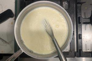 tempered egg yolks added to custard in a saucepan.
