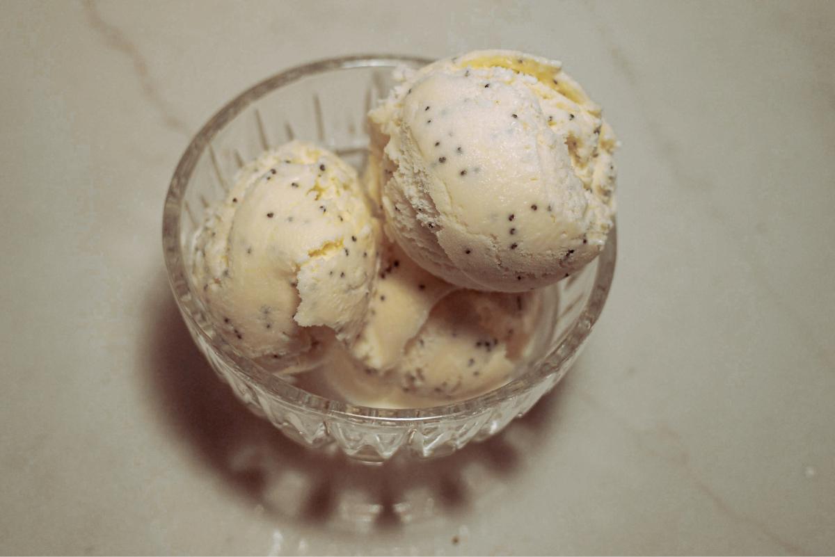 overhead view of 3 scoops of lemon poppy seed ice cream in a glass dish.