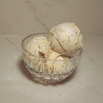 three scoops of lemon poppy seed ice cream in a glass dish.