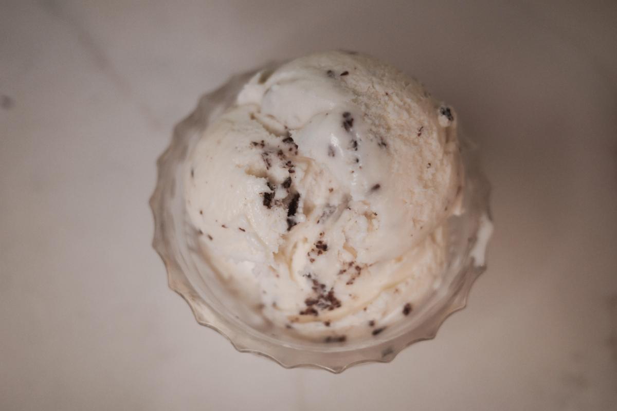 overhead view of three scoops of stracciatella ice cream in a glass bowl.
