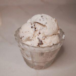 three scoops of stracciatella ice cream in a glass dish.