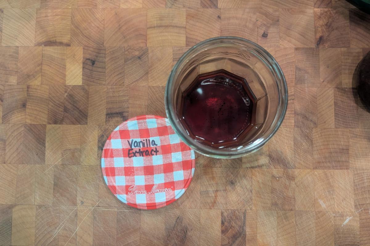 overhead view of homemade vanilla extract in a glass jam jar.