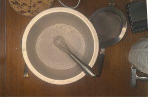 butterfly pea flower poweder, sugar, skim milk powder, and guar gum mixed in a metal bowl with a whisk.