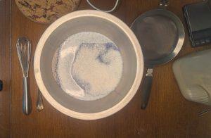 milk turning blue from butterfly pea flower powder in a metal bowl.