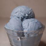 three scoops of blue vanilla ice cream in a glass bowl.