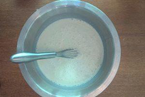 philadelphia ice cream base in a metal bowl with a whisk.