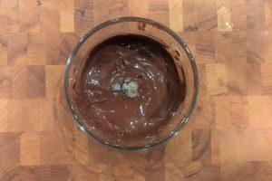 coconut oil added to melted chocolate in a bowl