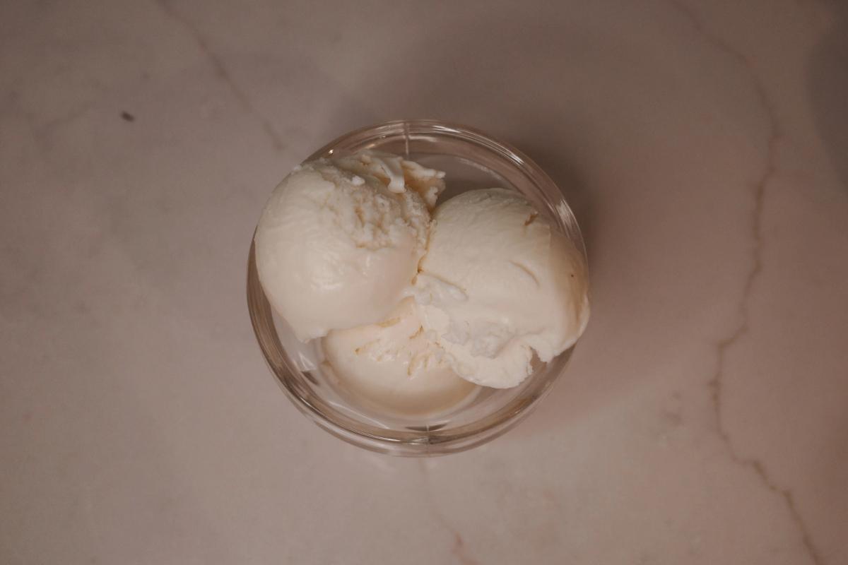 overhead view of three scoops of eggless philadelphia-style ice cream in a glass.