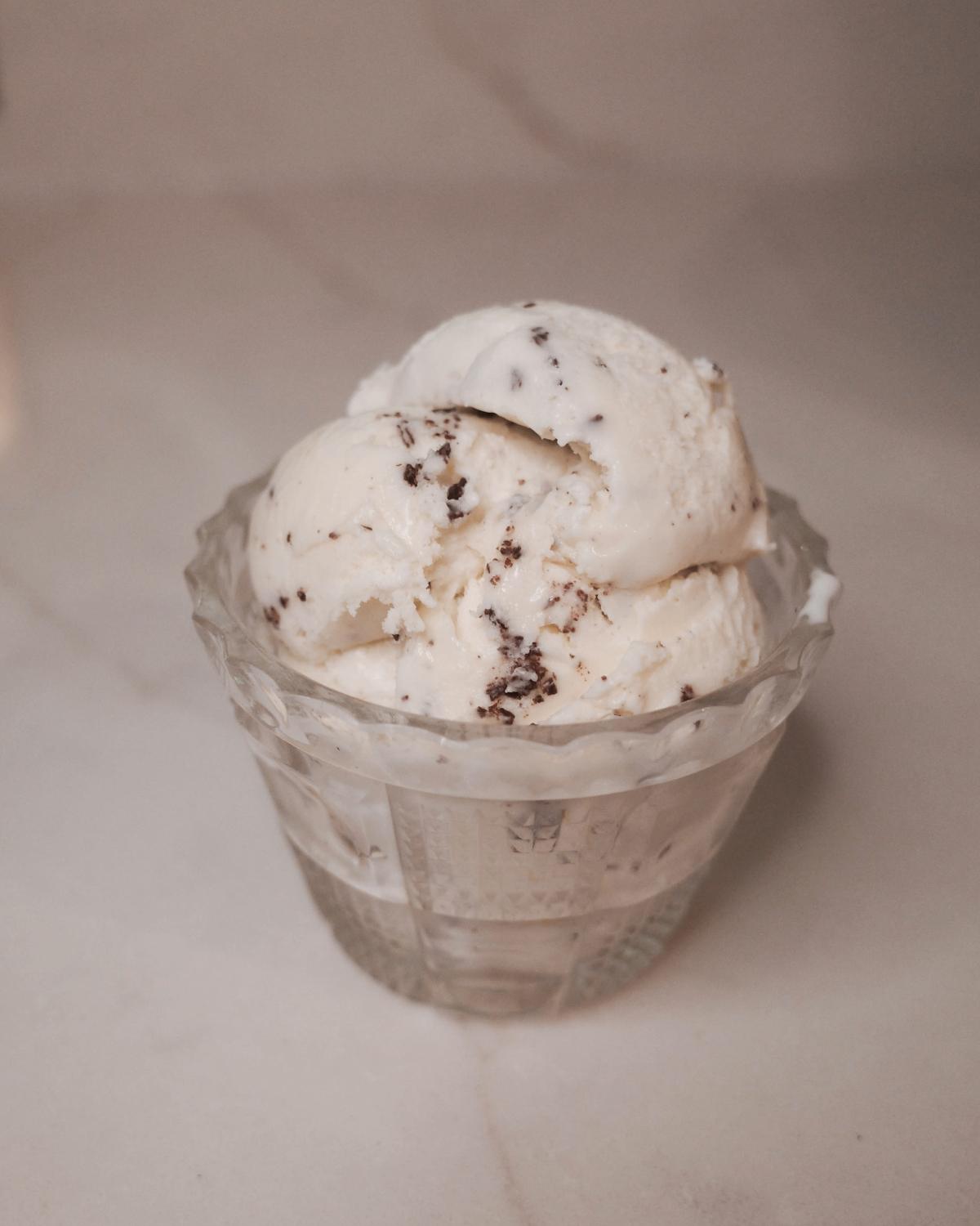 three scoops of stracciatella ice cream in a glass dish.