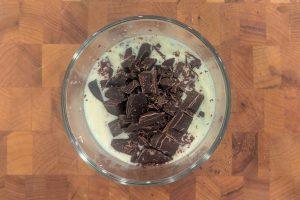 chopped chocolate in a bowl with warm cream and honey.