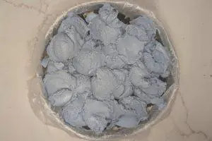 scoops of blue vanilla ice cream over a layer of ice cream cake crunchies in a springform pan.