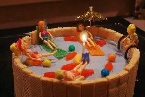 decorated swimming pool ice cream cake topped with a lit candle.