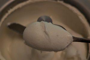 holding up a spoonful of freshly churned spiced ice cream.