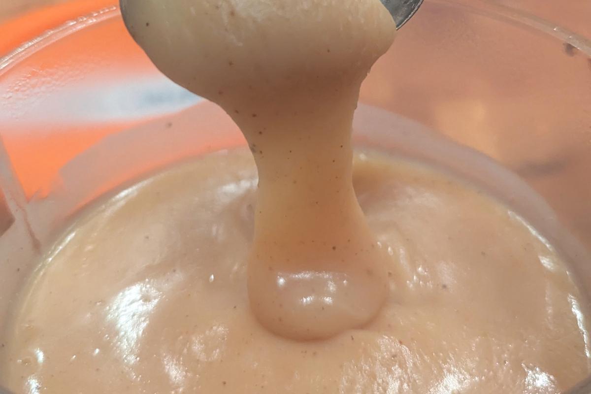 a ribbon of apple cider caramel dripping from a spoon.