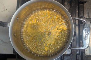 boiling apple cider in a saucepan.