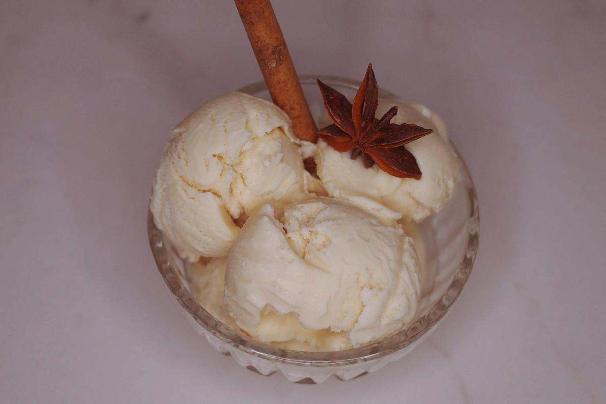 overhead view of scoops of chai apple cider ice cream with anise and a cinnamon stick garnish.