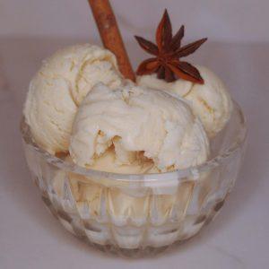 scoops of chai apple cider ice cream with anise and a cinnamon stick garnish.