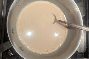 apple cider and chai-infused milk and cream in a saucepan.