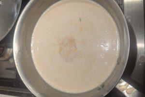 stirring apple cider syrup into heavy cream in a saucepan.